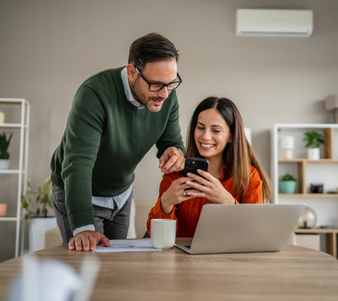 People looking at phone, smiling in office