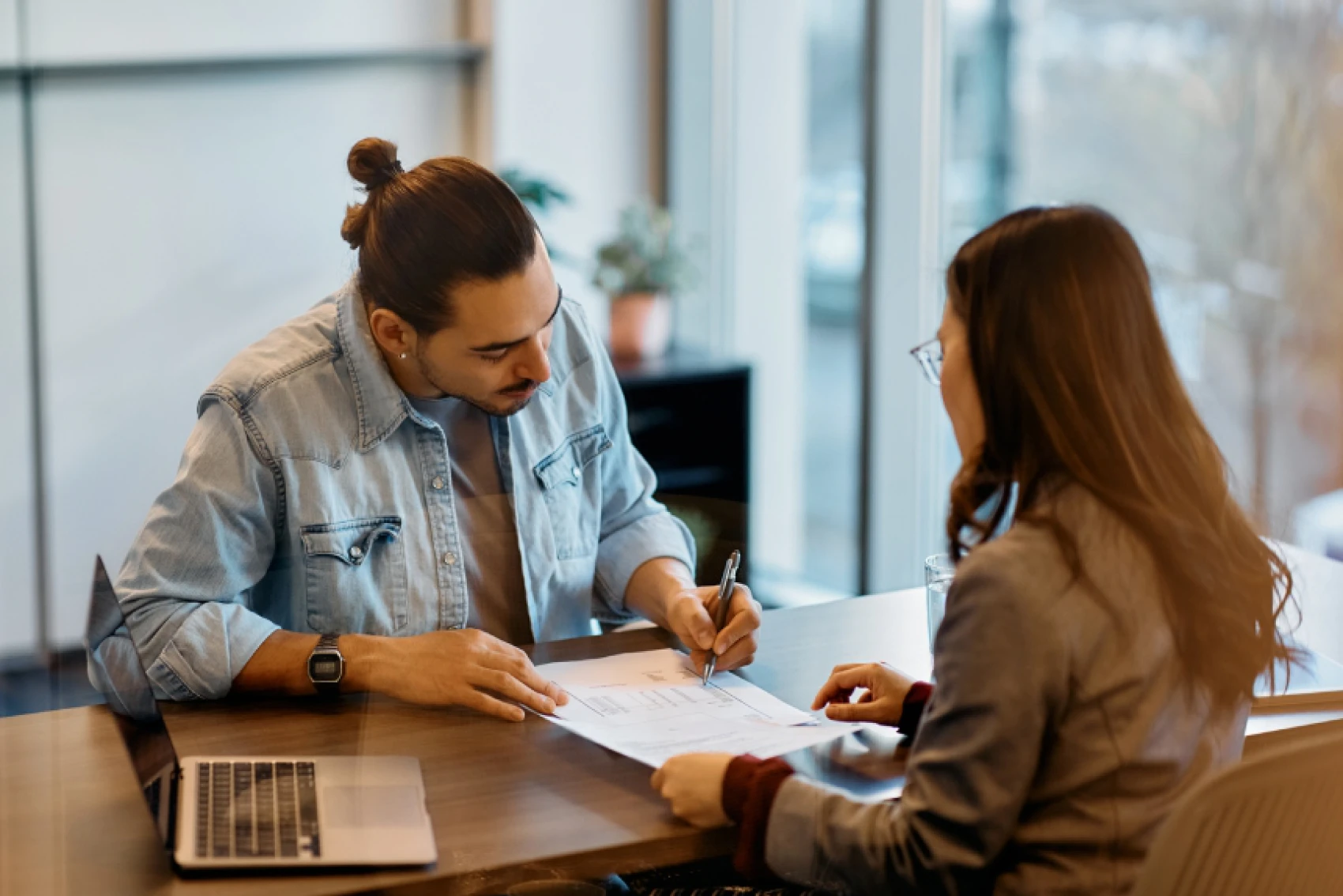 Man and woman discussing documents at table